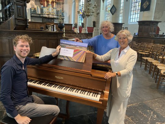 Neel Buijs (penningmeester) en Anke Ophoff (coördinator) ontvangen een cheque van 500 euro uit handen van ledenraadslid Eric Zwarthoed.